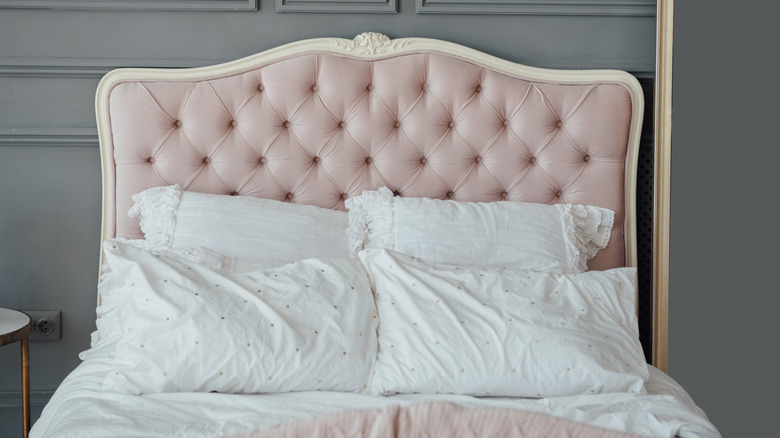 Bed with an upholstered headboard in pale pink