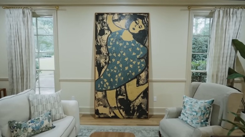 A large abstract painting in a traditional living room.