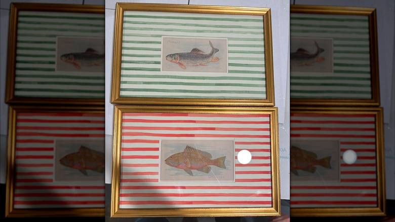 Two golden frames with fish prints and a decorative watercolor striped background.