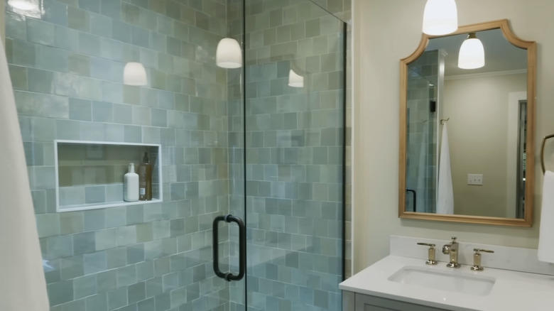 A shower with light blue green glass tiles