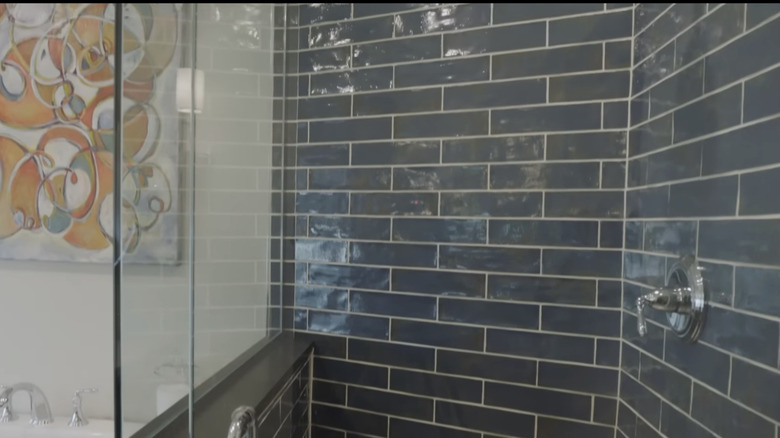 A large shower with navy blue subway tiles