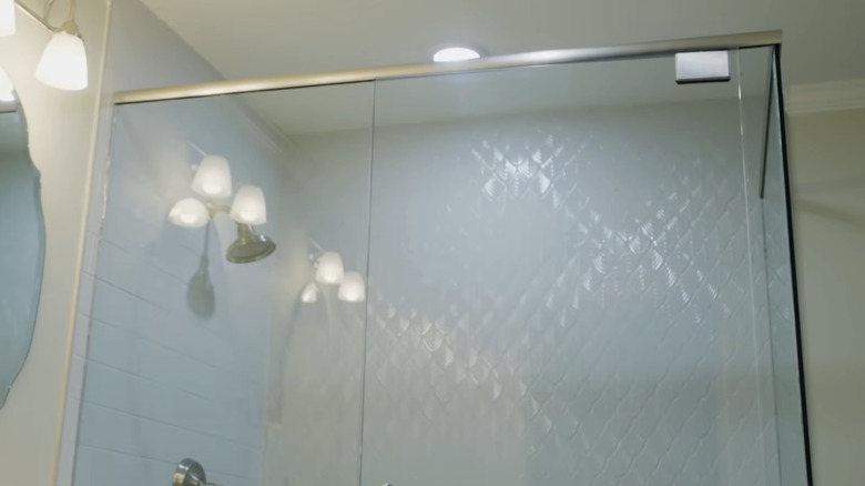 A shower with light blue textured tiles