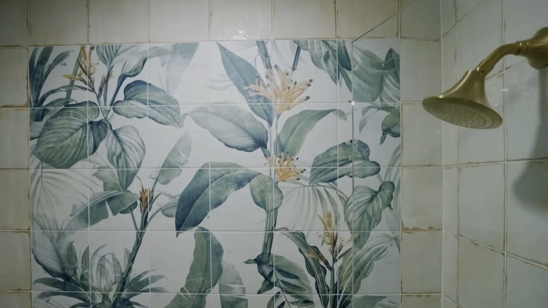 A shower with a palm tree tile mural