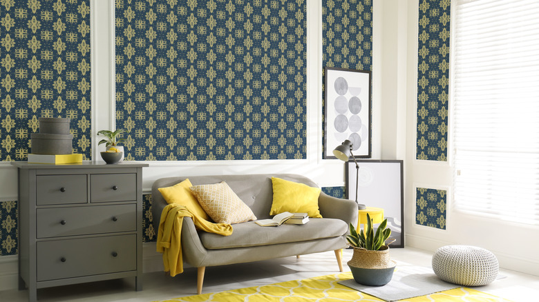 Stylish modern living room with a bold, gold and blue wallpaper pattern on the walls