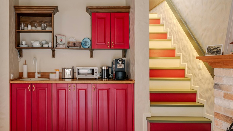 A coffee bar with burgundy cabinets