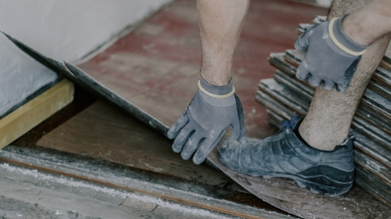 A man removing old linoleum from a floor