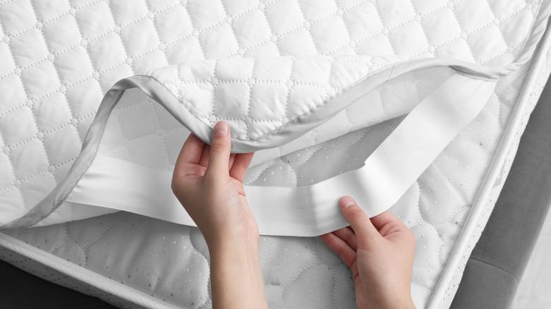 Person putting on mattress protector