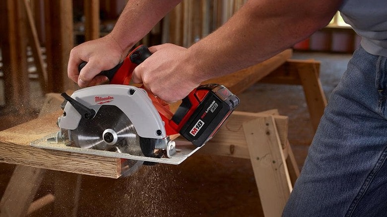 Person cutting wood with a circular saw