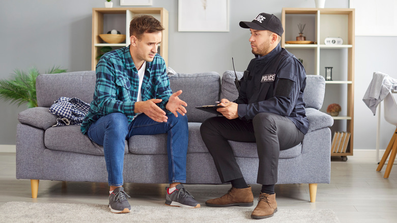 Man speaking with a police officer in his home