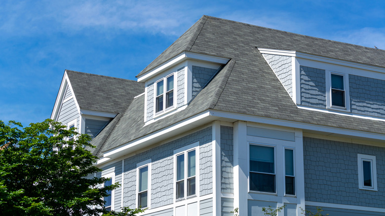 A house near Boston, with a grey facade and multiple dormers in the roof