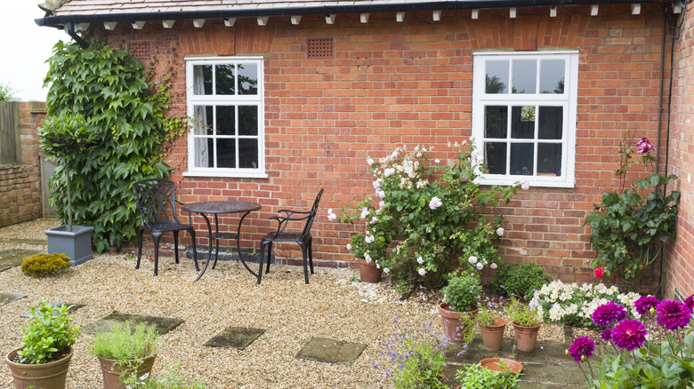 A small cottage backyard with a gravel patio space.
