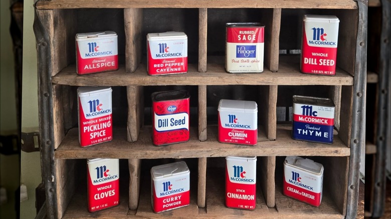 Collection of vintage spice jars set up in a wooden display case