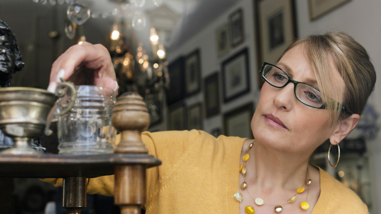woman examining some antique items