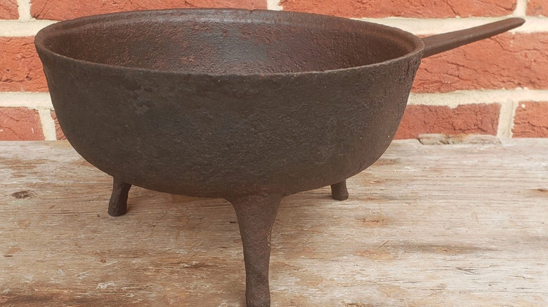 A cast iron spider skillet with a brick wall background