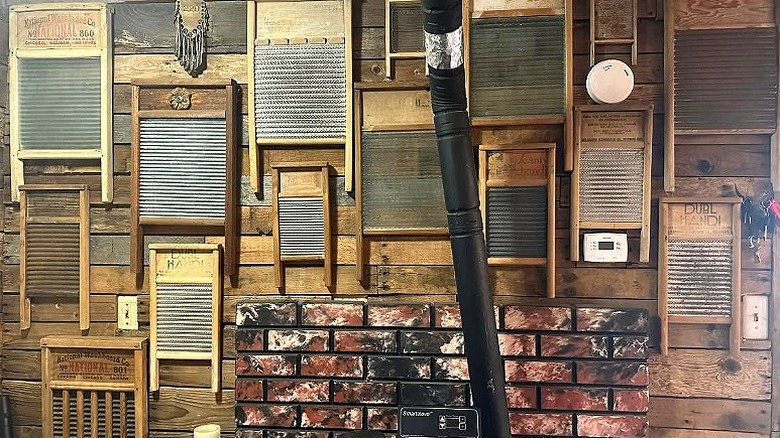 Collection of multiple wood washboards hanging on a wood panel wall near a pipe