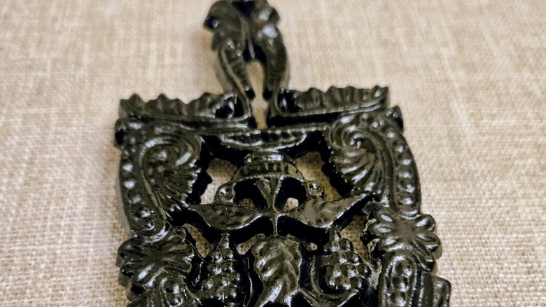 Victorian black cast iron trivet with grape motifs
