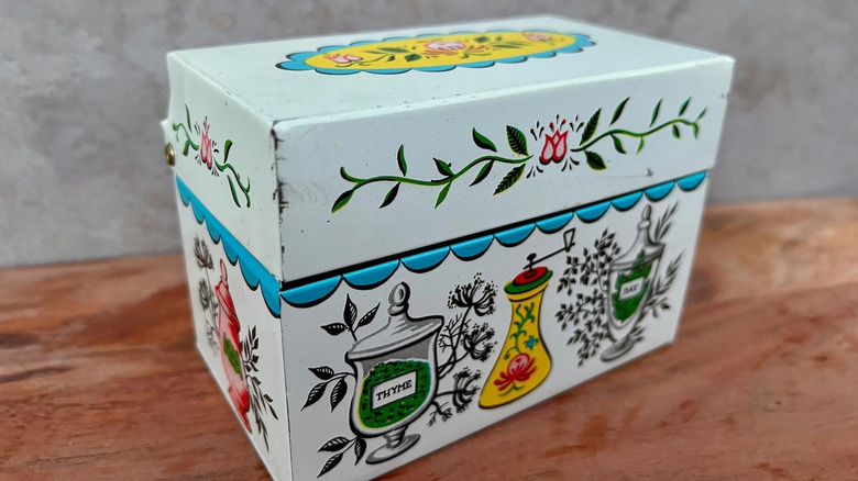 A vintage metal recipe tin with a quirky design.