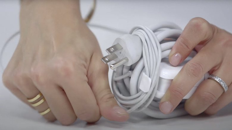 woman's hands wrapping Macbook charger