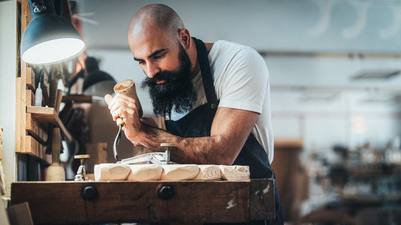 A man working with a chisel in a workshop