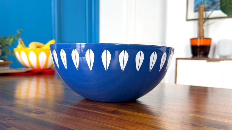 A vibrant blue Cathrineholm lotus bowl on a wood table