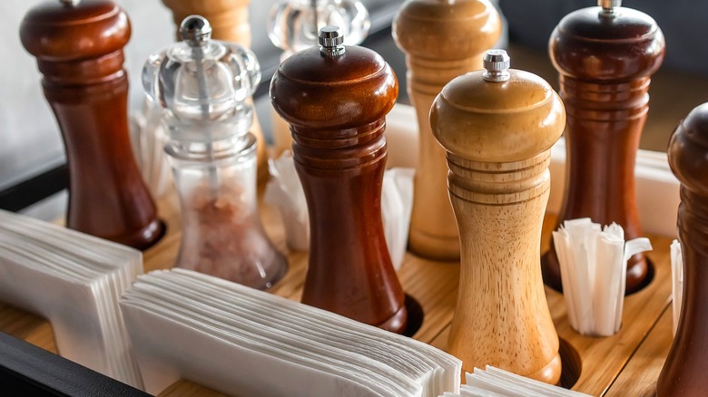 Tray holding napkins and different wood and glass pepper mills