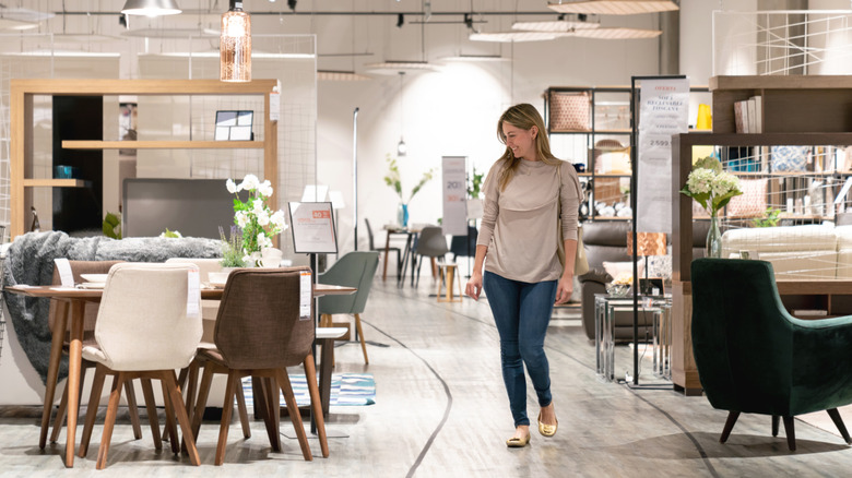 A woman shopping in a furniture store with a glass table in the background