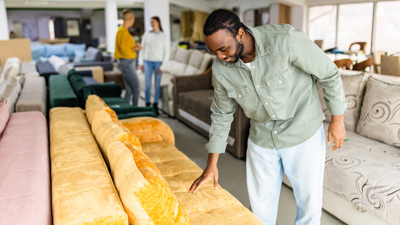 Man shopping for a sofa in showroom