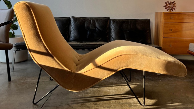 A yellow chaise lounge by Greta Magnusson Grossman (GMG) for Sherman Bertram from the 1960s in a mid-century modern styled living room.