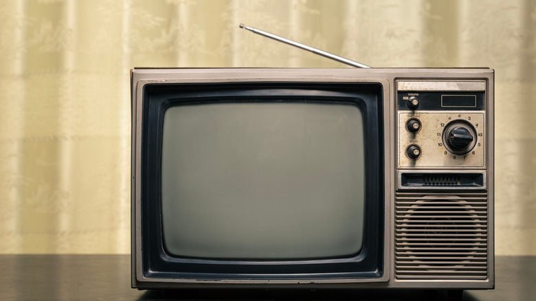 Retro old TV with antenna on table at home.