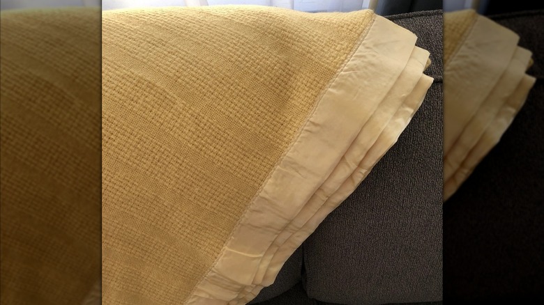 a beige Faribo blanket on a couch