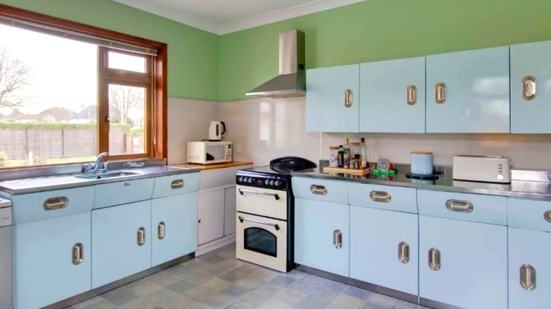 Light blue English Rose kitchen cabinets installed in a retro kitchen with green walls