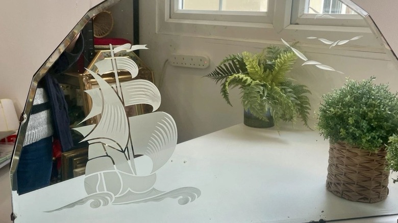Mirror etched with a ship and some birds