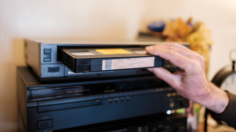 Inserting a VHS tape into a VHS recorder