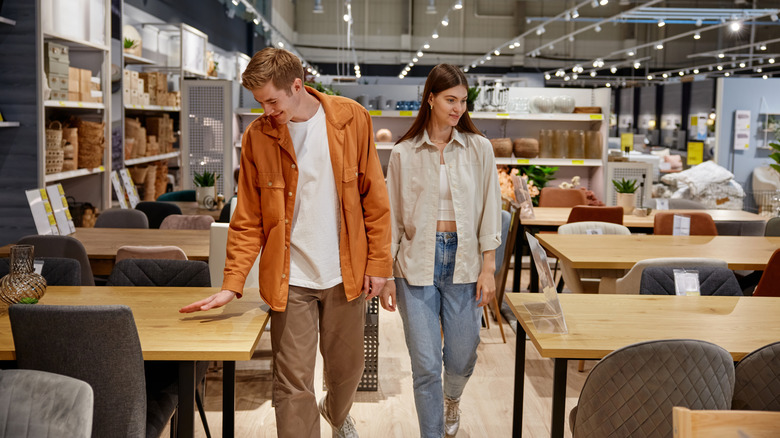 Couple checking out tables in furniture showroom
