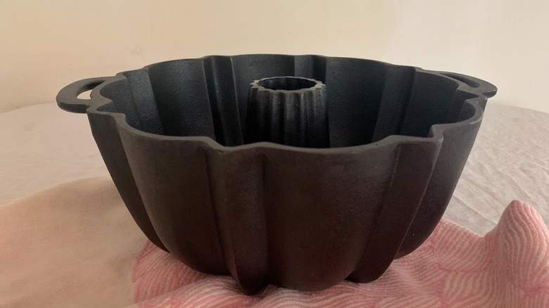 A vintage cast iron Bundt pan placed on top of a cloth