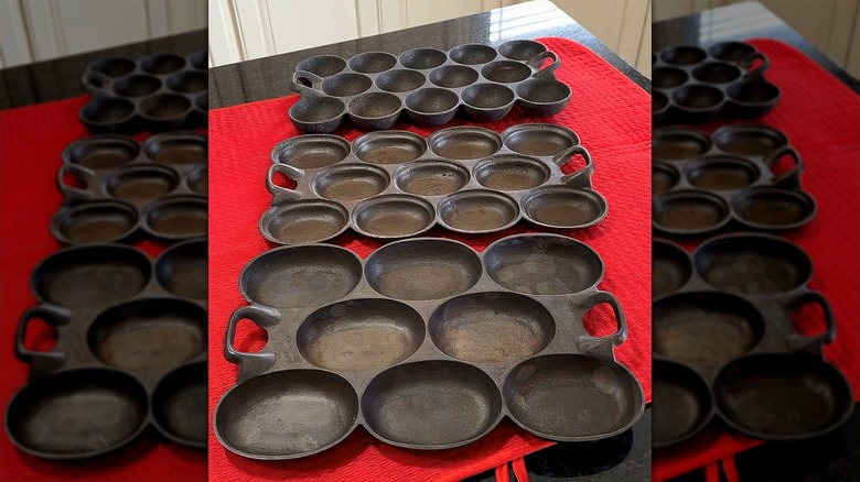Three types of gem pans arranged in a series on top of a red table cloth.