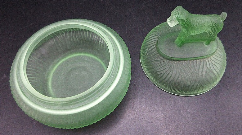 A frosted green glass L.E. Smith powder jar featuring a terrier figure on the lid