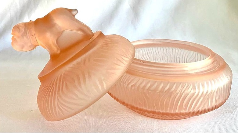 An L. E. Smith powder jar in light pink featuring a bulldog handle