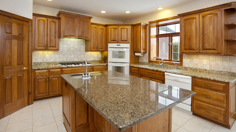 open kitchen with tile backsplash and dark granite countertops