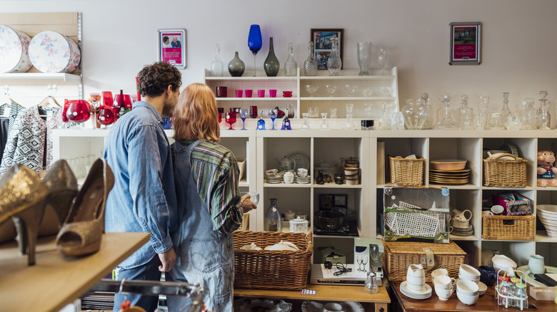 A couple looking at glass items in an antique store