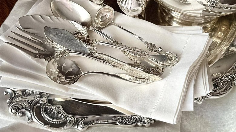 Grande Baroque silverware on a cloth napkin on top of a silver tray