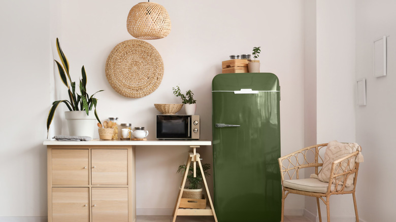 A streamlined modern kitchen with a green retro-style refrigerator.