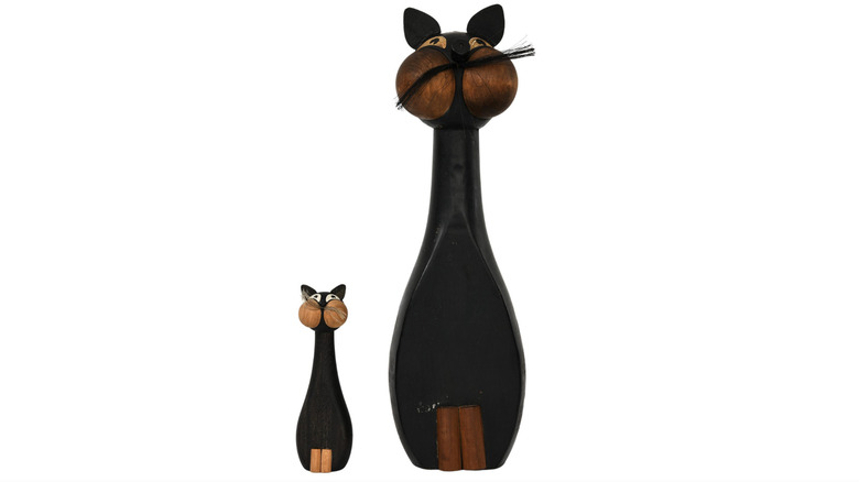 Small and large wooden cat figurines.