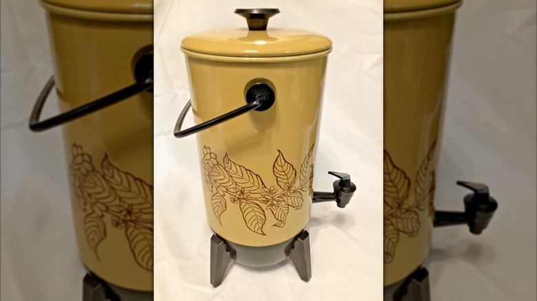 A harvest gold percolator with leaf design, on a table
