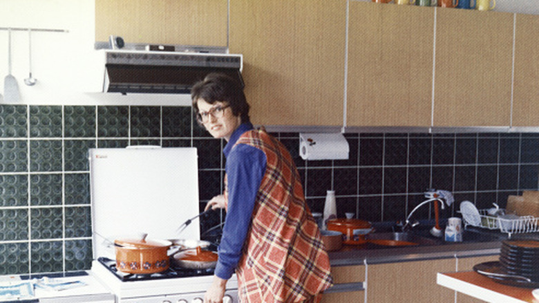 Woman cooking dinner in 1970s kitchen