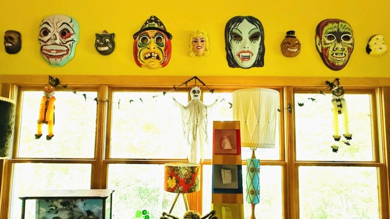Halloween masks hanging on the wall above a window