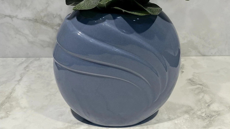 A round Haeger vase in blue with a draped embellishment carved into the pottery