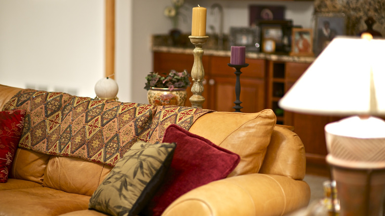 An early 2000s home with old world accents, brown tones, and a leather couch
