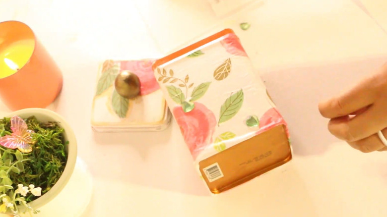 Decorative tea tin being embellished