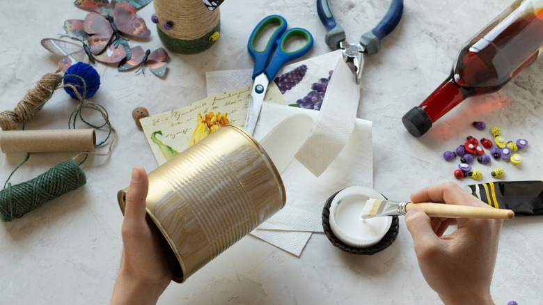 A woman decorating a tin can